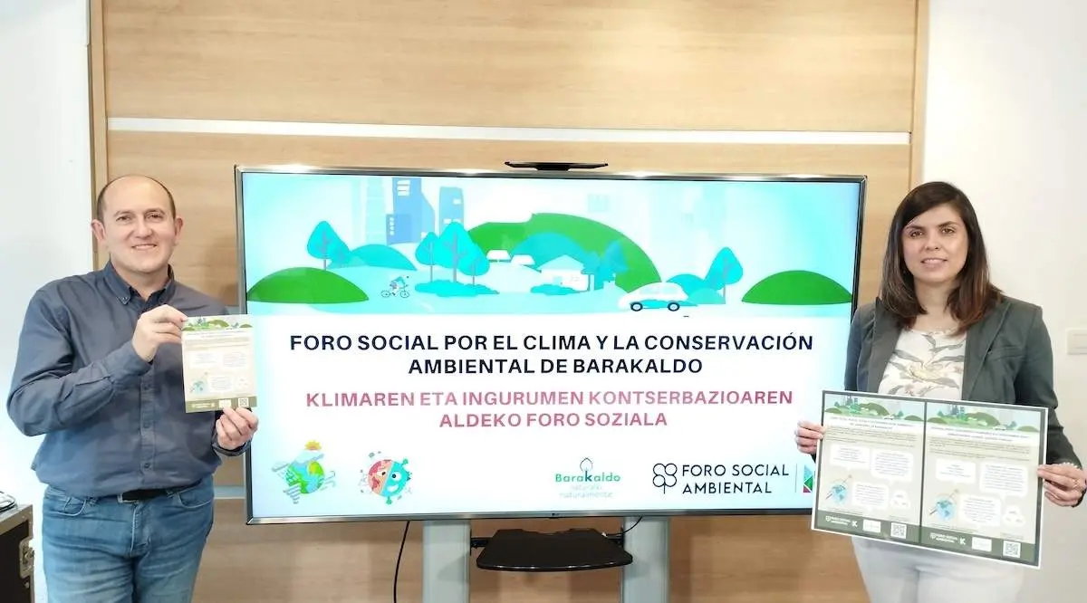 Foto de Carlos Fernández y Alba Delgado con los folletos y carteles del Foro Social Ambiental