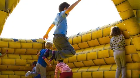 Ni&ntilde;os juegan en una zona de hinchables