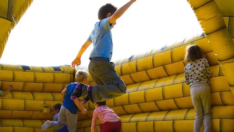 Ni&ntilde;os juegan en una zona de hinchables